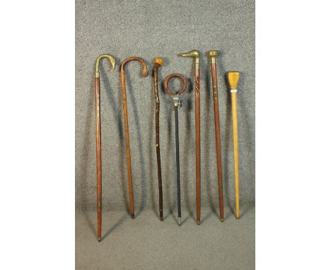 A collection of six vintage walking canes and a shooting stick. Three canes with brass finials, one of elephant form and a du