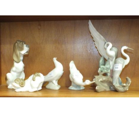 A collection of five Nao animal ornaments, including a group of two heron, 27cm high, a seated dog, 19cm, a playful puppy, a 