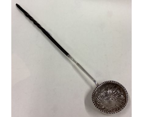 A Georgian silver toddy ladle with scroll decoration. Approx. 26 grams. Est. £50 - £80.