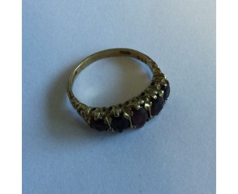 A garnet five stone half hoop ring. Approx. 4 grams. Est. £40 - £60.