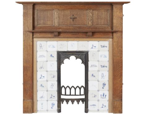 AN OAK FRAMED FIRE SURROUND  CIRCA 1920 AND LATER   the panelled surround enclosed with tiled panel, each tile printed in blu