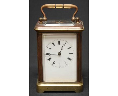 A brass carriage clock with white enamel dial and black Roman numerals, in a plain brass case with carrying handle. 15.25 cm 