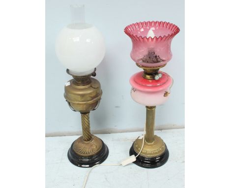 Two Victorian brass oil lamps, one with ruby glass shade.