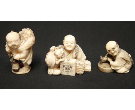 Three Japanese ivory netsuke, one carved as a figure wearing goggles and working a stone with wheel with an adze, signed, ano