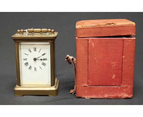 An early 20th century brass carriage timepiece, with white enamel dial, in original leather and velvet-lined slip case