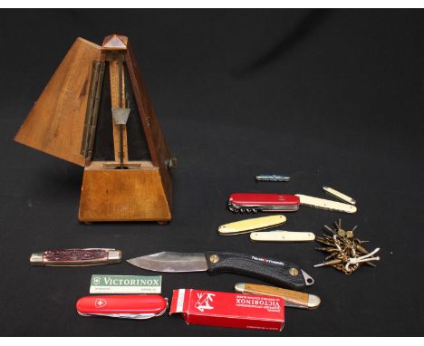 A collection of pocket knives, together with a mahogany metronome.