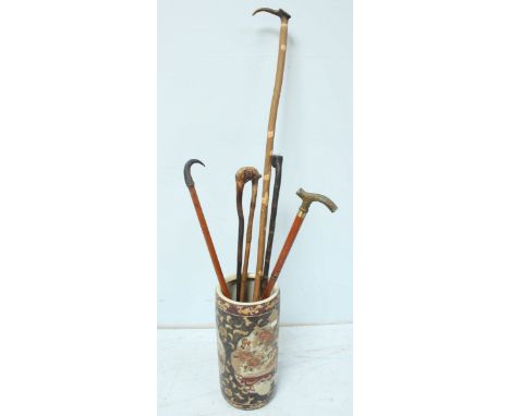 A modern Chinese porcelain stick stand, together with a collection of walking sticks.