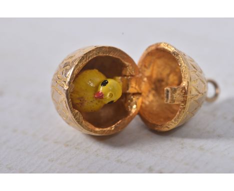A 9CT GOLD EGG AND CHICK CHARM, yellow gold egg with hinged fittings opening up to reveal an enamel chick, approximate height