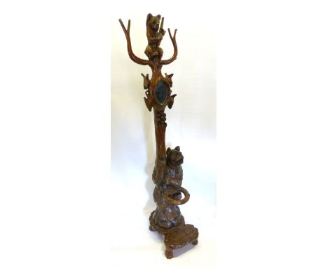 A Black Forest Stick Stand, in the form of bears with oval mirrored column and low shaped feet, 180 cms tall