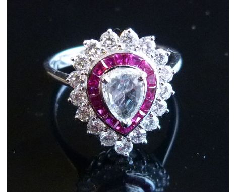 An 18ct. White Gold Ruby and Diamond Ring, with central pair cut diamond surrounded by rubies and diamonds, approximately 0.9