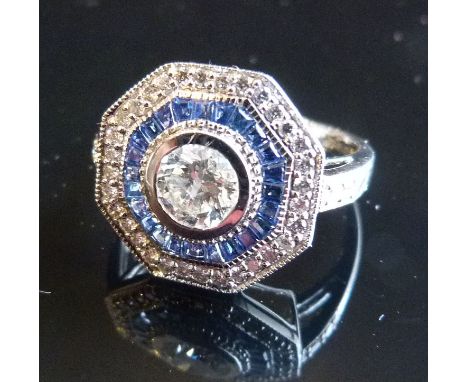 A 14ct. White Gold Art Deco Style Ring, set with large central diamond surrounded by sapphires and diamonds with diamond shou