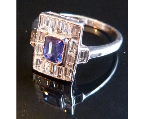 An 18ct. White Gold Sapphire and Diamond Ring with central rectangular sapphire surrounded by baguette cut diamonds and with 