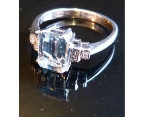 An 18ct. White Gold Aquamarine and Diamond Ring, with central rectangular aquamarine opposed by four baguette cut diamonds 