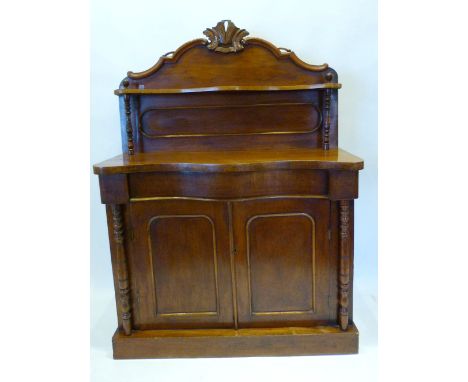 A Victorian Mahogany Serpentine Chiffonier, the galleried shelf back above a concealed frieze drawer and two panelled doors f