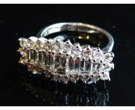 An 18ct. White Gold Diamond Cluster Ring, with baguette diamond surrounded by diamonds within a pierced setting, approximatel