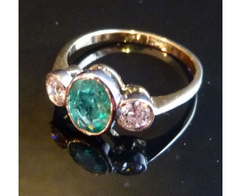 An 18ct. Yellow Gold Emerald and Diamond Ring, with large central oval emerald opposed by two diamonds within a pierced setti