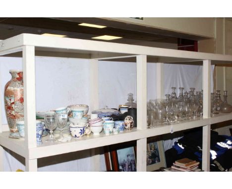 Full shelf of glass and china including decanters, Satsuma vase, teaware etc.