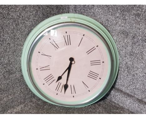 A large IKEA wall clock with green painted metal frame.