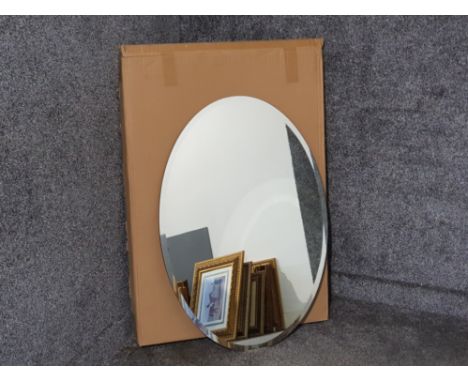 Large frameless oval shaped mirror, with both horizontal and vertical hooks to back, boxed