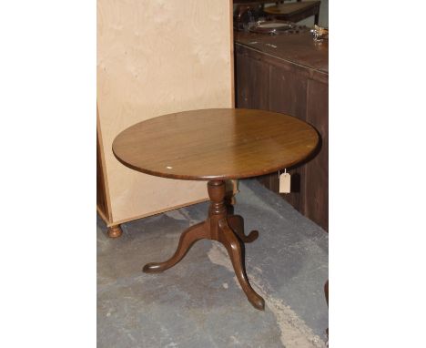 A Georgian oak tripod tableThe circular top raised on a ring turned baluster shaft with downswept supports and pointed pad fe