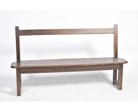 A late 19th/early 20th Century stained pine bench Having a rail back above a rectangular seat with rounded corners supported 