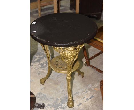 A painted Britannia cast iron pub tableThe circular hardwood top supported on three cast openwork legs, each centred with a B