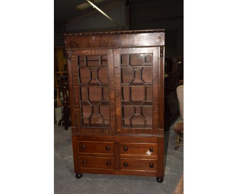 A Georgian mahogany glazed bookcaseHaving a bobbin turned frieze above a pair of astragal glazed drawers enclosing three shel