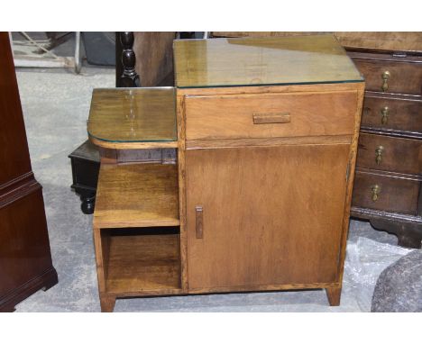 A 1930's Art Deco side cabinet Having a single frieze drawer above a cupboard door opposed by a rounded shelf and square pige