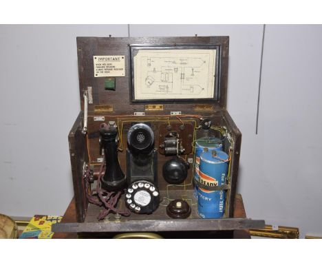 A wooden cased operators telephone, mid 20th CenturyWith dialing pad, batteries, bell, speaker & receiver.  Instructions to l