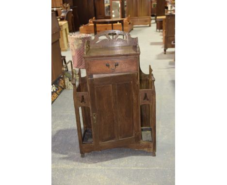 An early 20th Century oak "Arts & Crafts" hall cupboard stick standHaving a rectangular open work gallery above a single frie