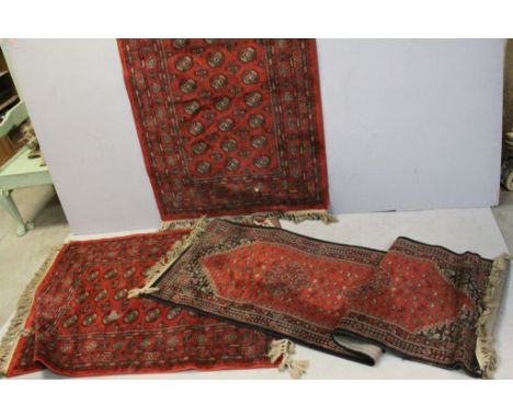 Pair of Red Ground Rugs with Geometric Patterns, 98cms x 140cms together with Red and Blue Ground Runner Rug, 210cms x 64cms