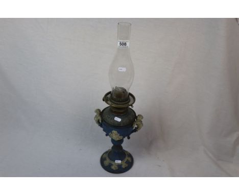 An antique table oil lamp with cast spelter base with Jasper ware style decoration, cherub handles and one other brass base w