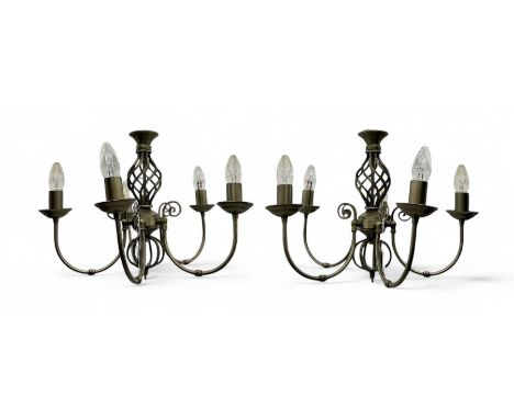 Pair of brass five-branch chandeliers, each featuring scrolling arms with candle-style light fittings, centred by a twisted o