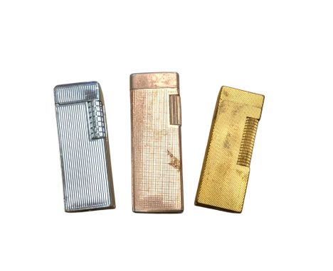 Dunhill gold plated lighter with engine turned decoration, with two other lighters