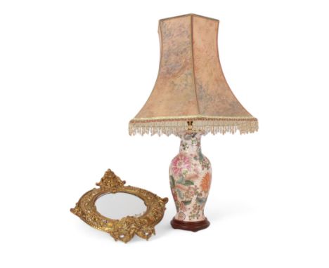 Brass circular mirror decorated with cherub and mythical masks, together with a table lamp decorated with stylised flowers, m