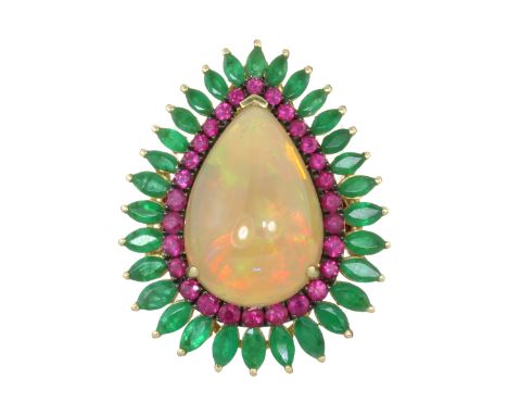 AN ETHIOPIAN OPAL, RUBY AND EMERALD COCKTAIL RING in 18ct yellow gold set with a large, central pear shaped cabochon opal of 