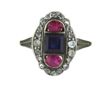 AN ANTIQUE ART DECO SAPPHIRE, RUBY AND DIAMOND RING in high carat yellow gold set with a step cut blue sapphire flanked by tw