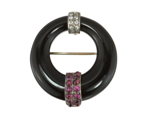 AN ANTIQUE ART DECO ONYX, RUBY AND DIAMOND BROOCH in 18ct white gold designed as a graduated black onyx hoop with decorative 
