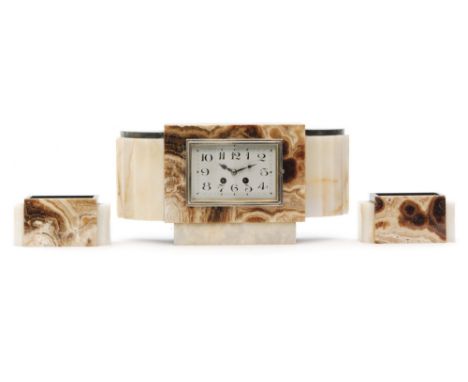French, Unknown - A polished marble, slate and onyx clock garniture, the clock with ribbed concave side panels and with a sil