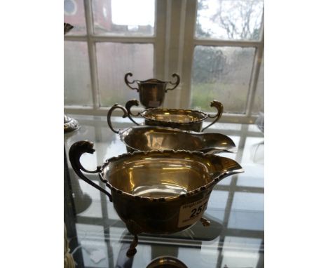 A mixed lot of silver items comprising two small sauceboats, a four footed sugar basin, and a small presentation trophy cup m