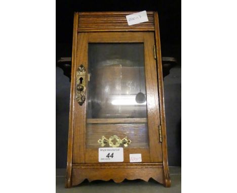 A late 19th/early 20th Century oak smokers cabinet, with pipe racks and tobacco jar.