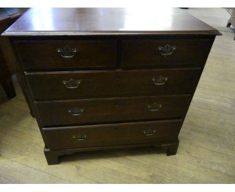 A Georgian oak chest of two short over three long drawers, raised on bracket supports, of small proportions.