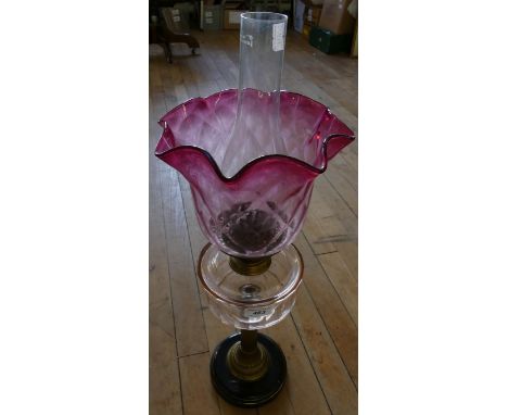 A late 19th/ early 20th Century oil lamp with frilled glass shade and font with brass column base