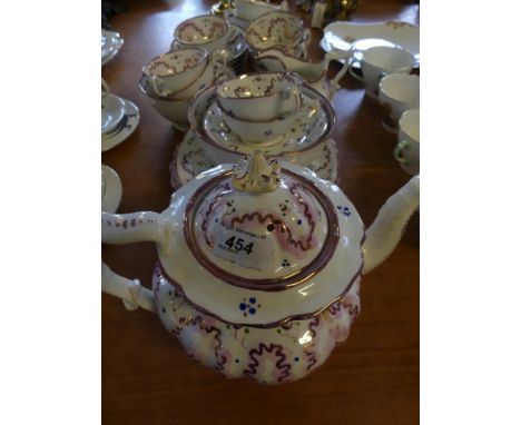 A 19th Century Staffordshire puce lustre tea service decorated with floral designs.