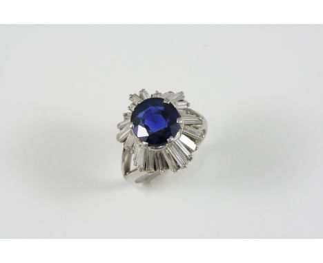 A SAPPHIRE AND DIAMOND SET 'BALLERINA' CLUSTER RING the oval-shaped sapphire is set within a surround of baguette-cut diamond