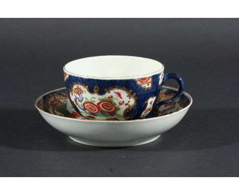 WORCESTER BLUE SCALE TEACUP AND SAUCER, circa 1770, painted with floral sprays inside gilt cartouches, script W to cup and se