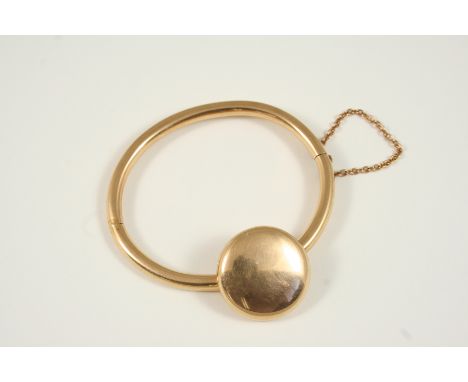 A GOLD HALF HINGED BANGLE mounted with a circular swivel locket containing hair and inscribed to the inside T.S. Oct. 22nd. 1