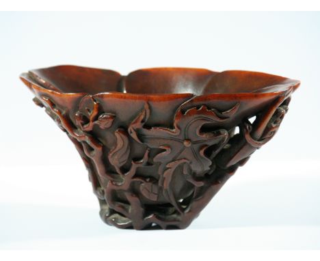 CHINESE RHINOCEROS HORN LIBATION CUP, 19th century, carved with dragons amongst scrolling foliage, height 8cm, width 16cm, de
