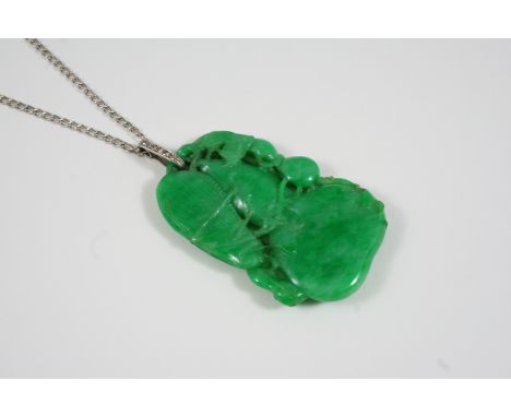 A JADE AND DIAMOND PENDANT the carved, pierced and polished jade formed as a gourd mounted with insects, with circular diamon