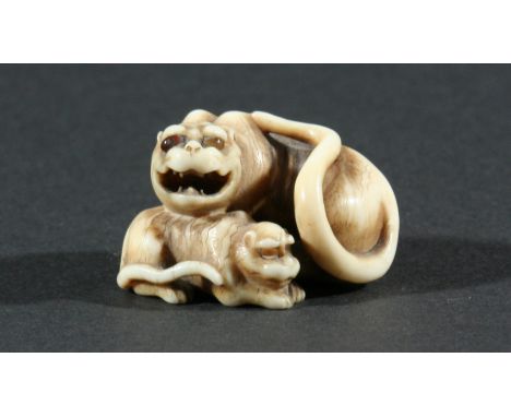 JAPANESE IVORY NETSUKE, carved as a tigeress and her cub, height 3.5cm
